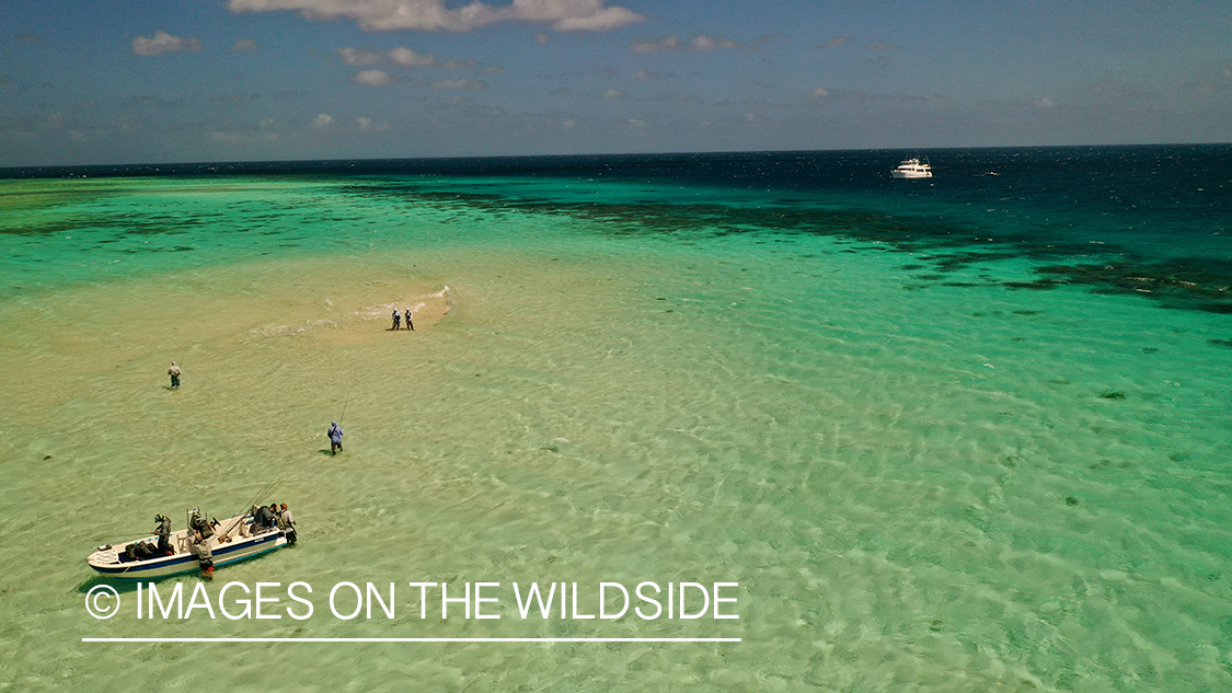 Ariel view (drone) saltwater flyfishing along Great Barrier reef with liveaboard in view.