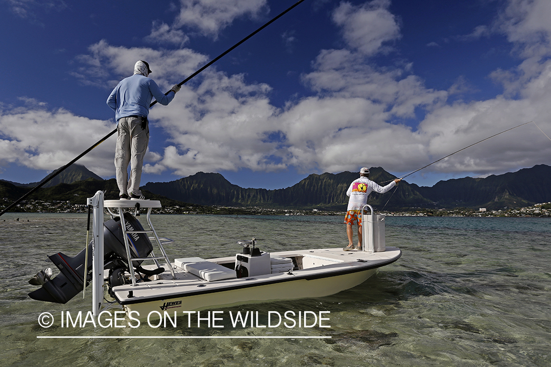 Saltwater flyfishermen fishing on flats boat, in Hawaii.