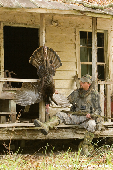 Turkey hunter in field with bagged bird