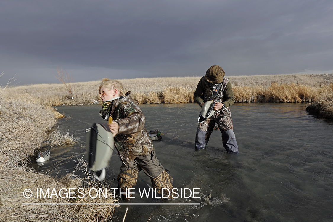 Father and son collecting decoys waterfowl hunting.