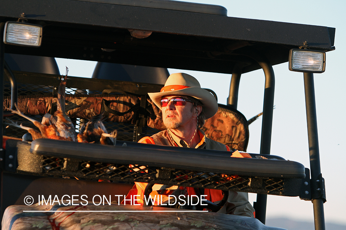 Upland game bird hunters with bagged pheasants in ATV.