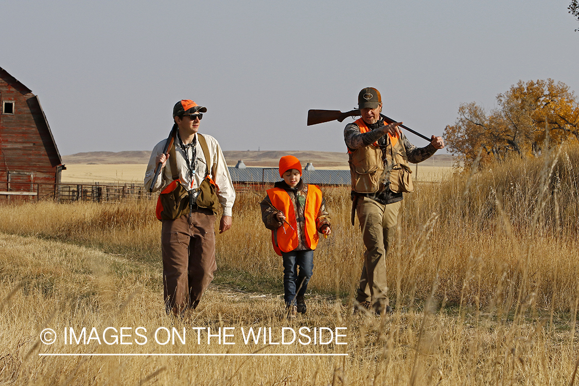 Father and sons hunting game bird.