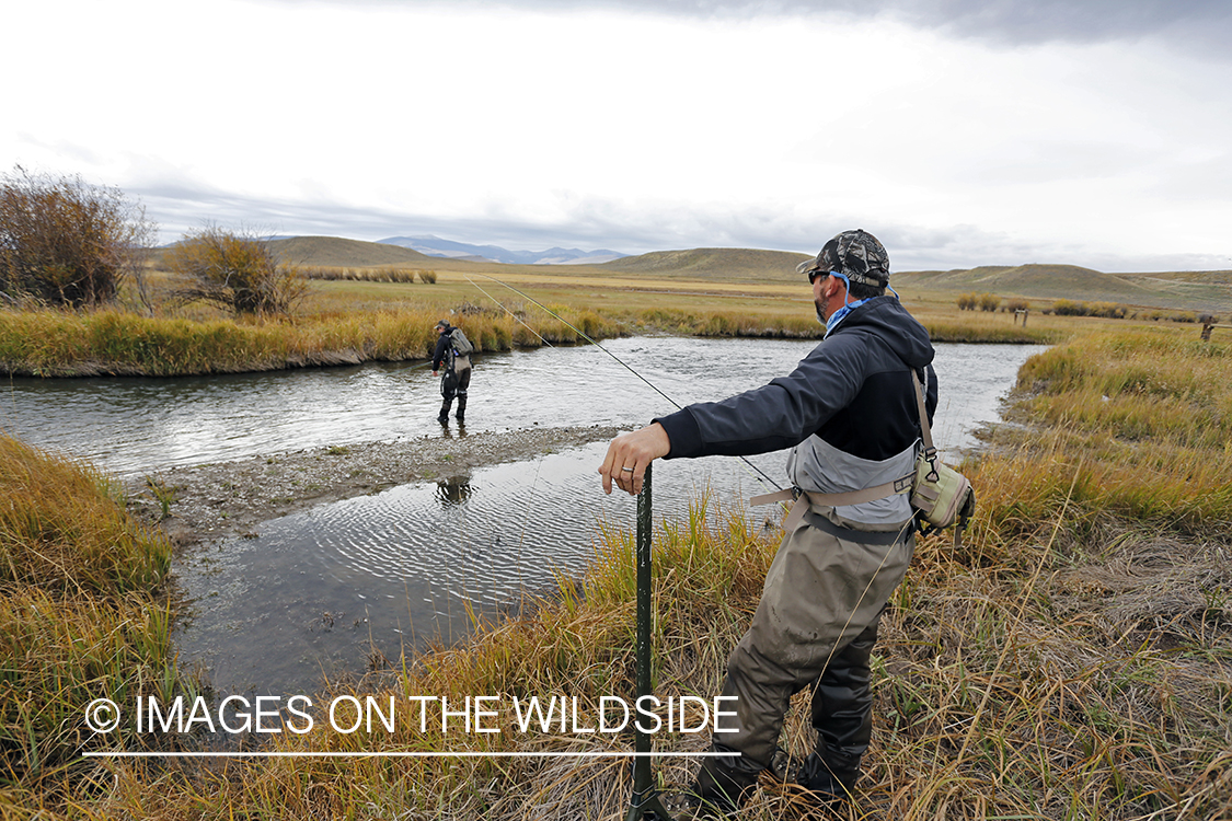 Flyfishermen casting on river. 