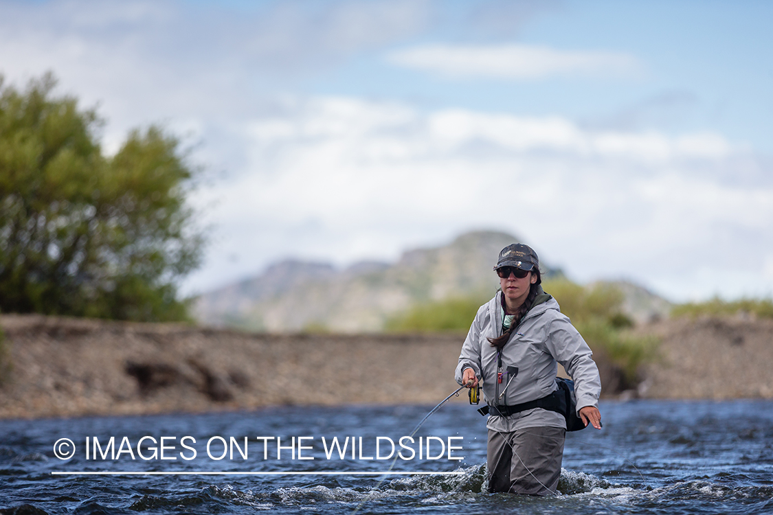 Woman fly fishing guide(Marcela Appelhanz) on stream.