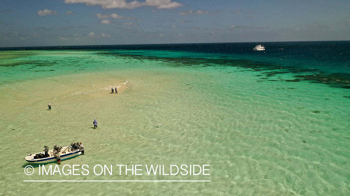 Ariel view (drone) saltwater flyfishing along Great Barrier reef with liveaboard in view.