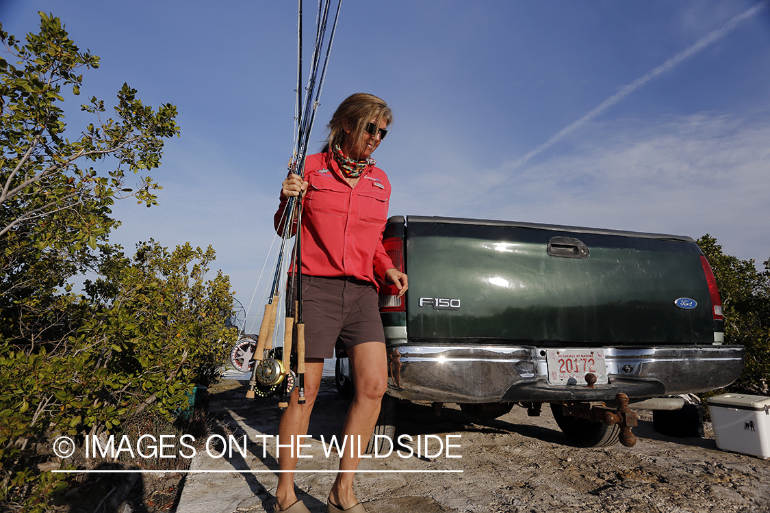 Saltwater flyfishing woman loading rods on airboat.