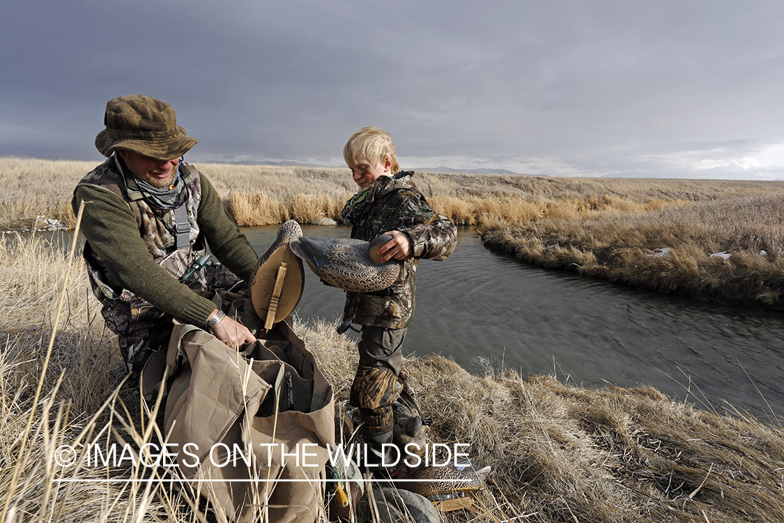 Father and son collecting decoys waterfowl hunting.