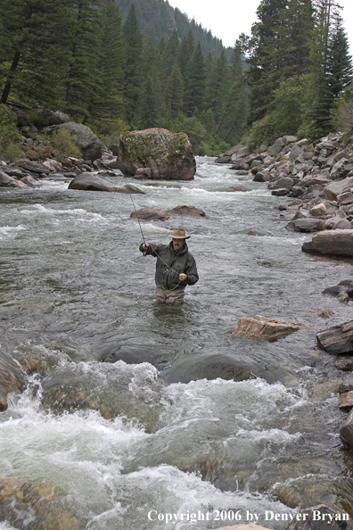 Flyfisherman fishing water pocket in river.