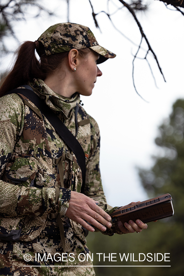 Women hunter with turkey call.