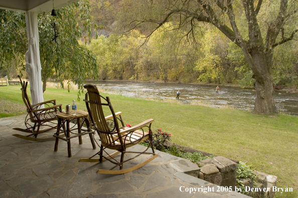 Flyfishermen on Pennsylvania spring creek with club house in foreground.