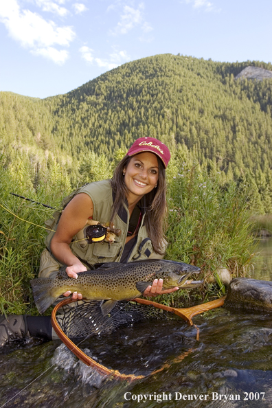 Woman flyfisher with large brown trout.