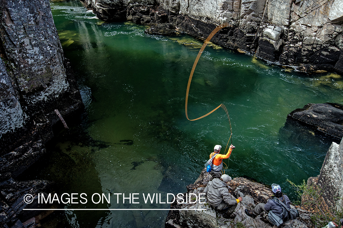 Flyfisherman casting to stream in canyon.