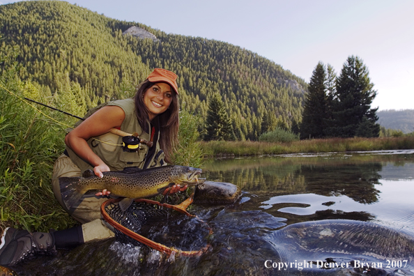 Woman flyfisher with large brown trout.