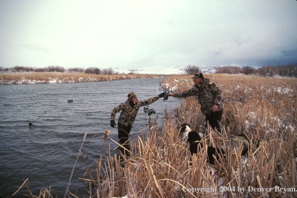 Waterfowl hunters placing decoys.