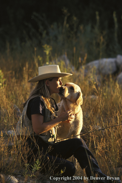 Woman flyfisher with yellow Lab.