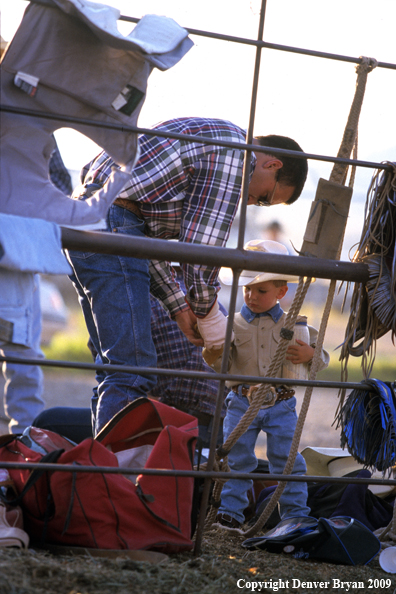 Father helping young cowboy