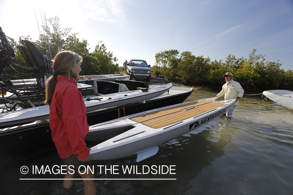 Saltwater flyfishermen loading paddle board on airboat.