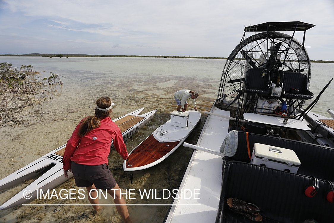 Saltwater flyfishermen loading paddle board on airboat.