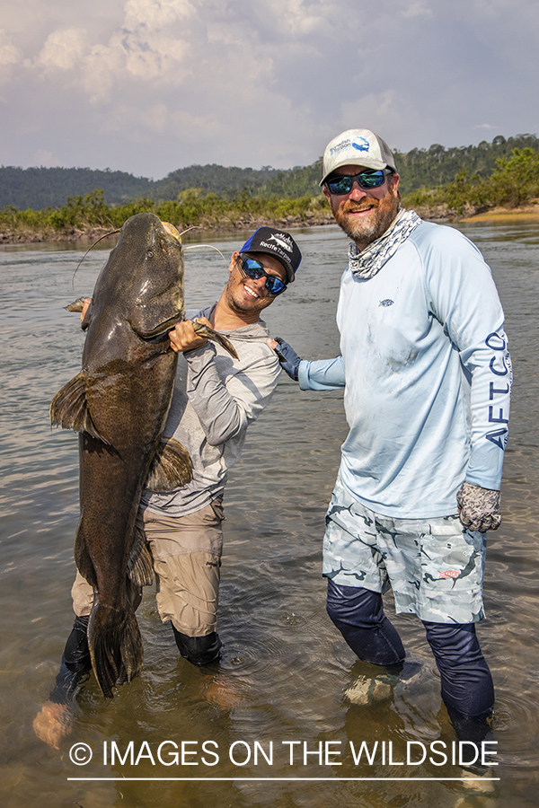 Flyfisherman with catfish on Amazon River in Venezuela.