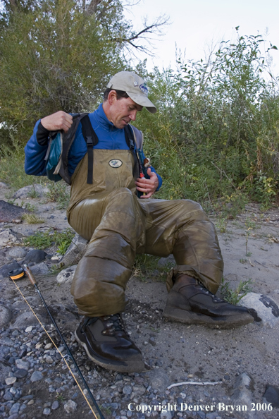 Flyfisherman on the river with waders full of water.  