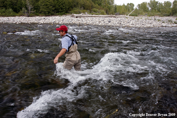 Flyfisherman crossing river