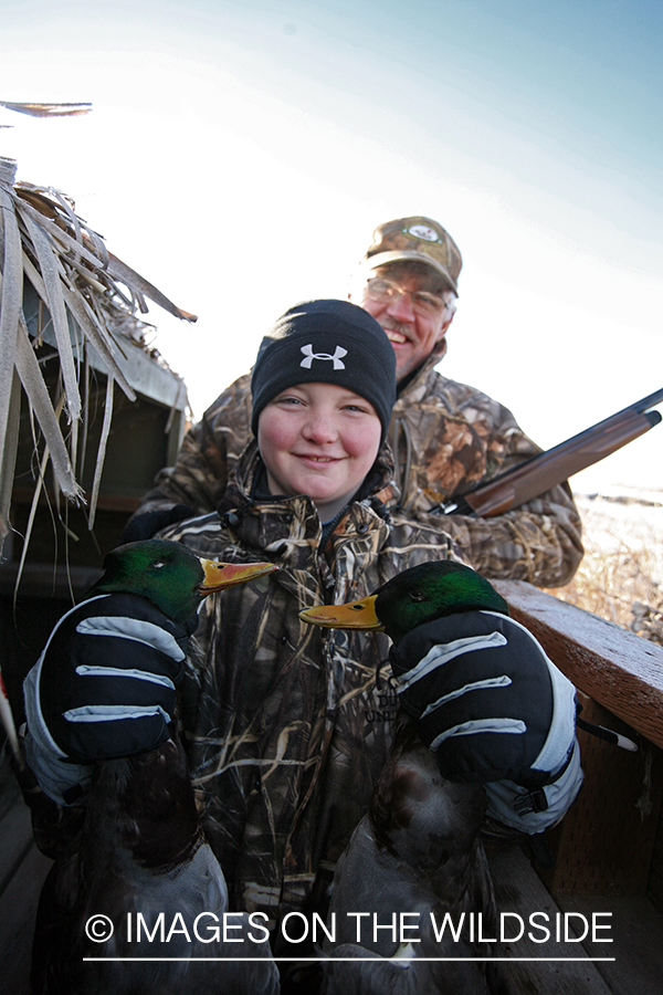 Young hunter with bagged mallards.