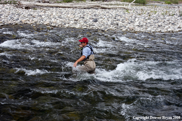 Flyfisherman crossing river