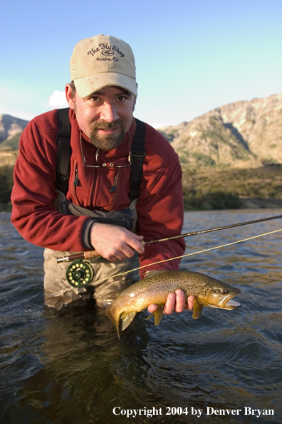 Flyfisherman holding brown trout.