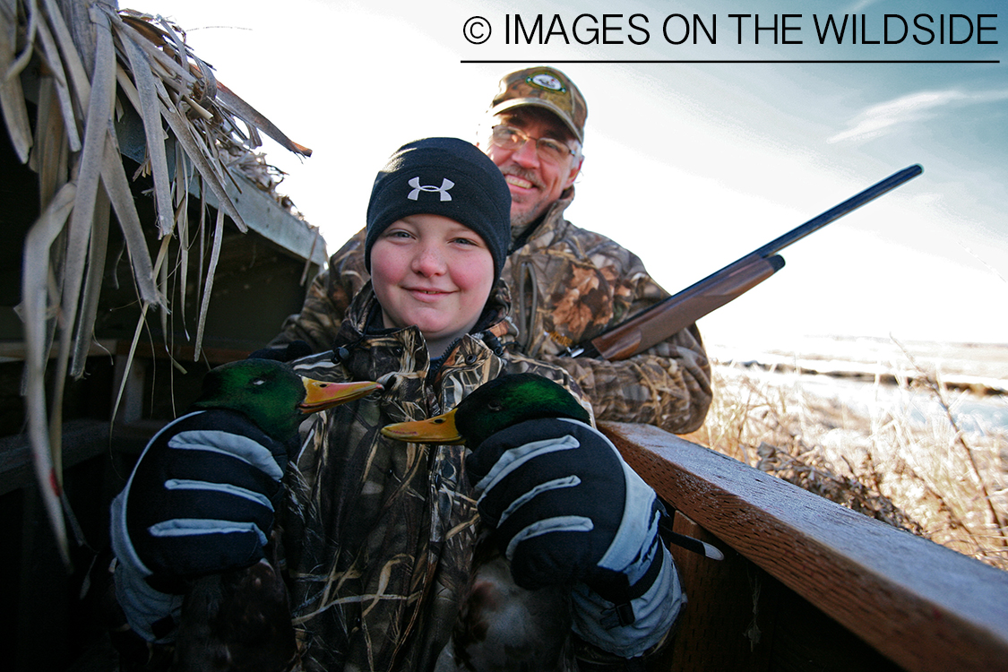 Young hunter with bagged mallards.