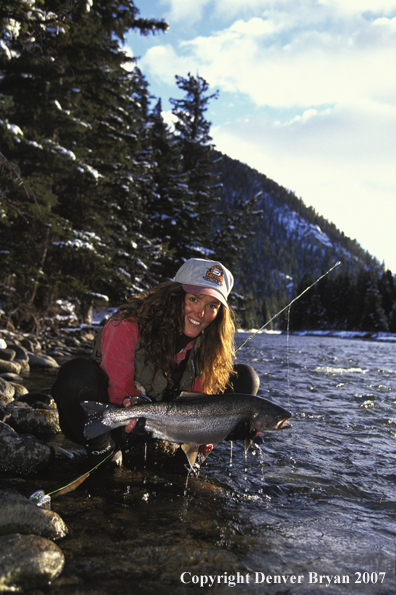 Woman flyfisher with rainbow trout. 