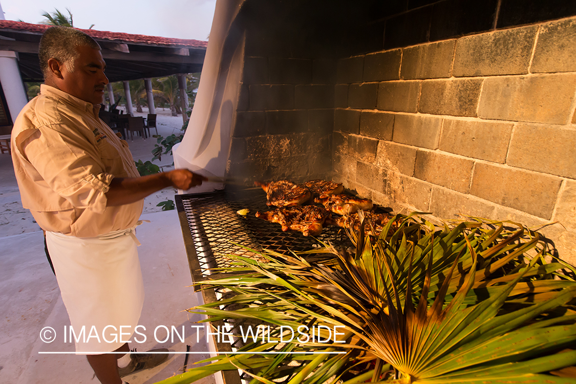 Man cooking on grill in Belize.