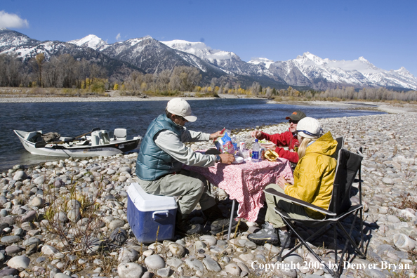 Flyfishermen having a shore lunch on the banks of the Snake River.