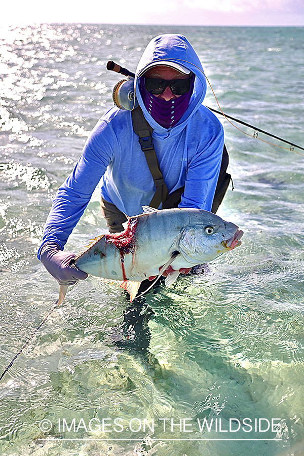 Flyfisherman with shark bitten giant trevally.