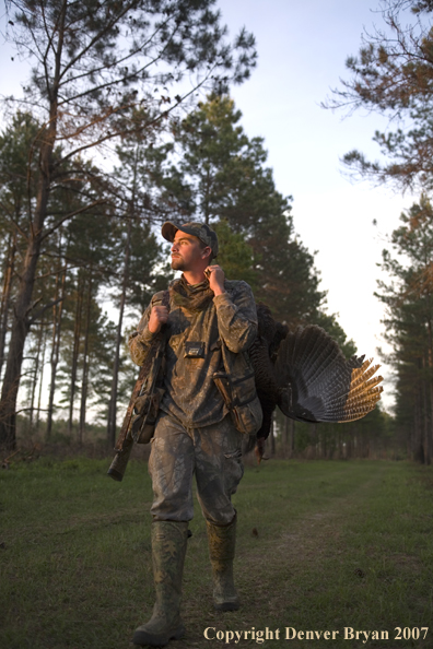 Turkey hunter in field with bagged bird