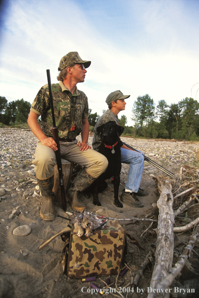 Father and son dove hunting with Labrador Retriever.