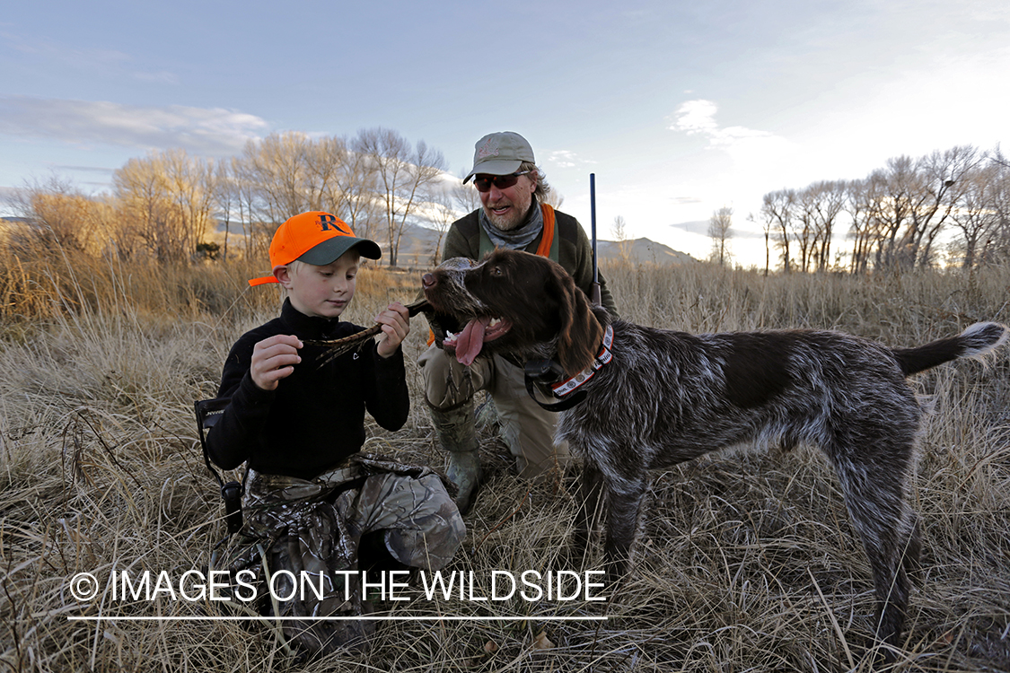 Father and son pheasant hunters with bagged pheasant. 