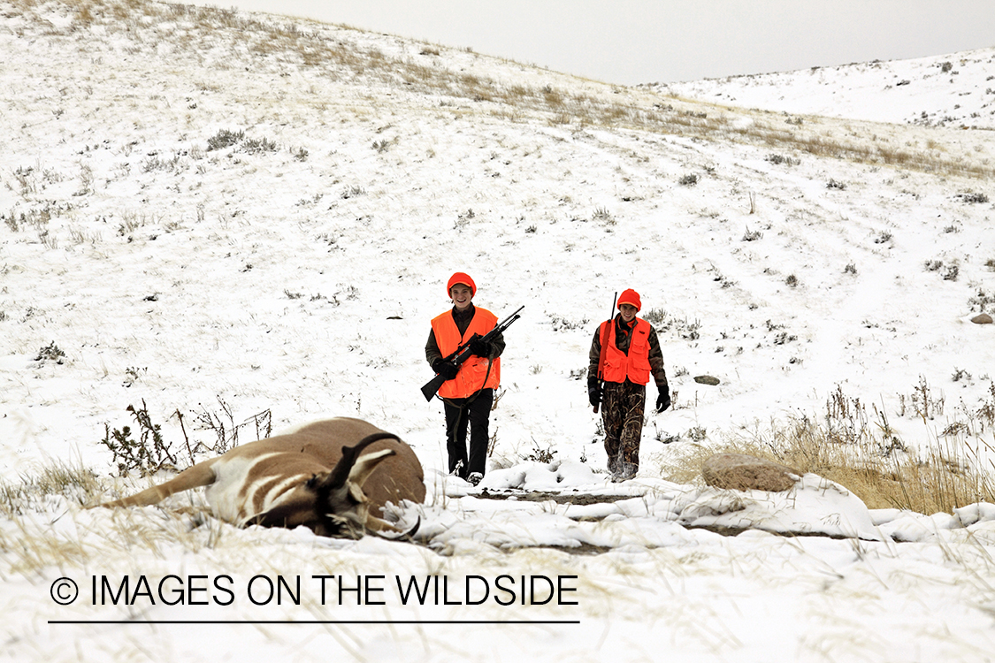 Young hunters approaching bagged pronghorn antelope. 