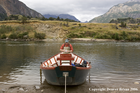 Flyfisherman choosing fly in driftboat.