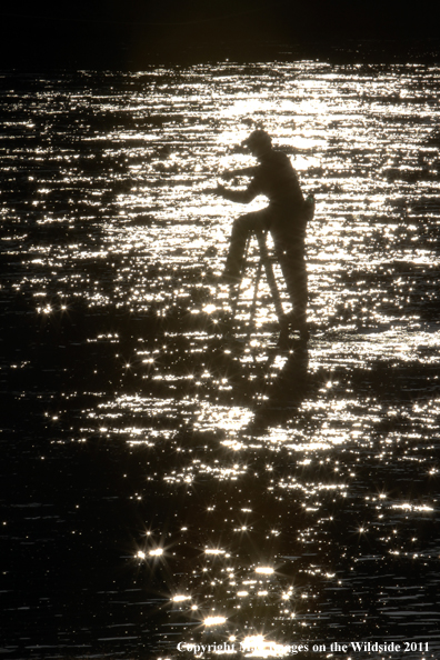 Flyfisherman casting from ladder in middle of river.