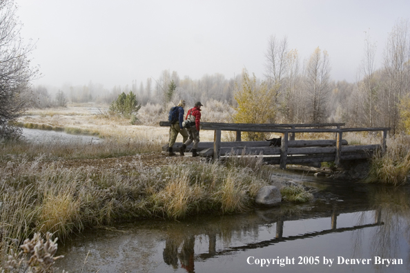 Flyfishermen approaching foot bridge.