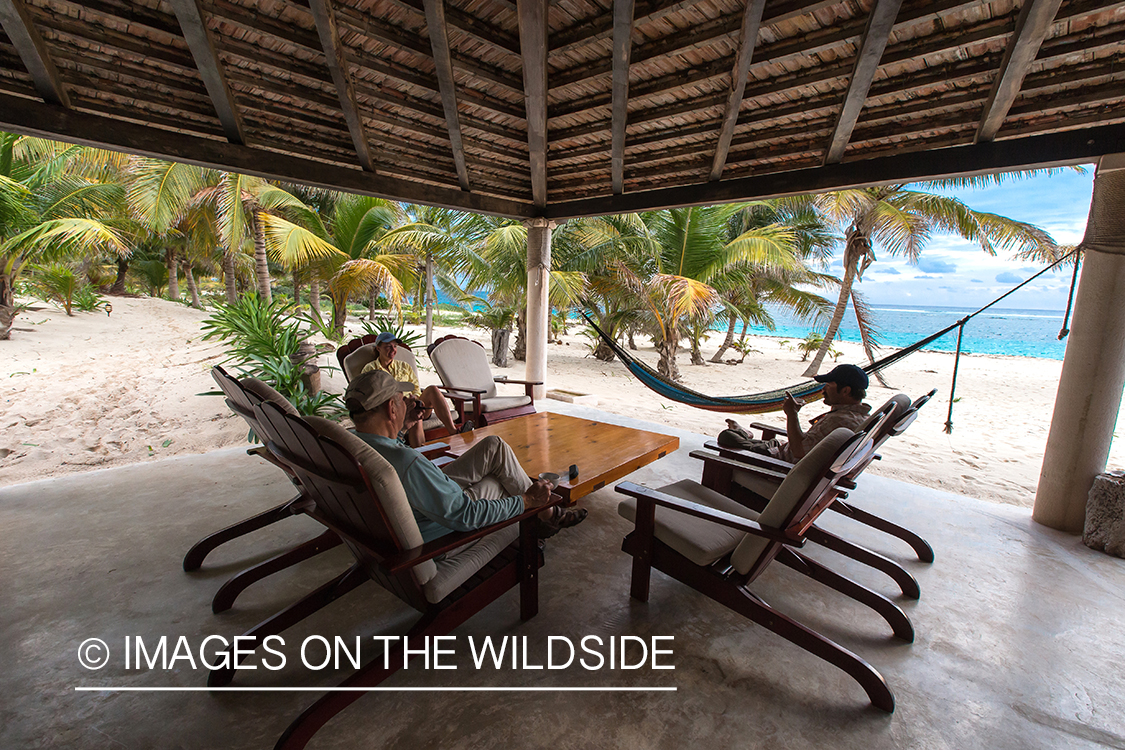 Flyfisherman sitting in lodge at beach.