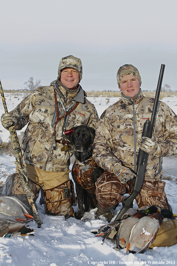 Waterfowl hunters with dog and downed waterfowl. 