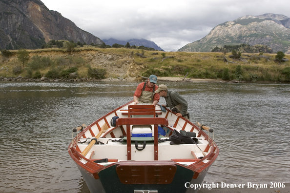 Flyfishermen choosing fly at driftboat.