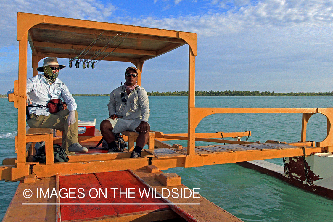 Saltwater flyfisherman with guide on boat, Christmas Island.