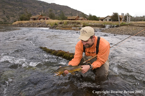 Flyfisherman holding brown trout.