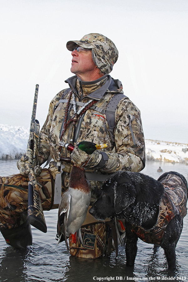 Waterfowl hunter with dog and downed waterfowl.