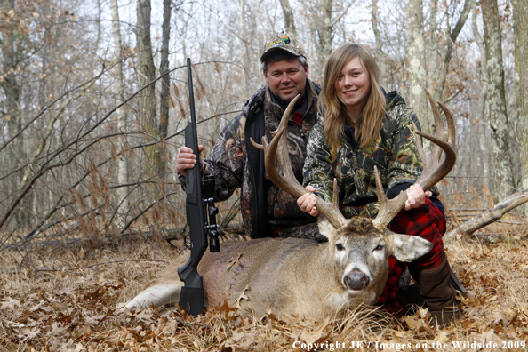 Hunters with bagged whitetail buck.