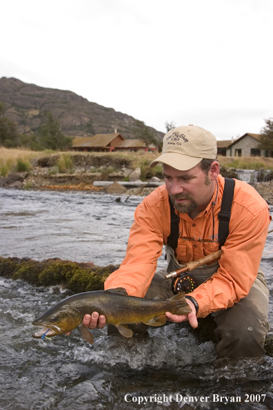 Flyfisherman holding brown trout.