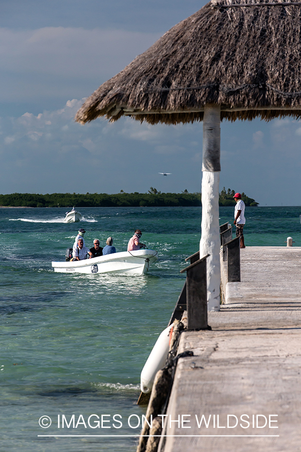 Flyfishermen in boat returning to dock.