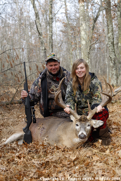 Hunters with bagged whitetail buck.